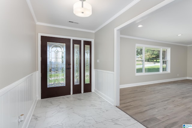 foyer with crown molding and light tile patterned floors