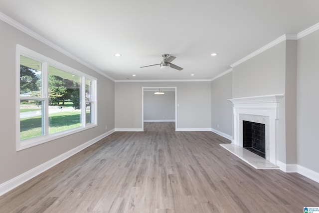 unfurnished living room with ceiling fan, light hardwood / wood-style floors, a high end fireplace, and ornamental molding