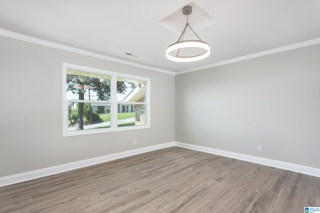 spare room with ornamental molding and hardwood / wood-style flooring