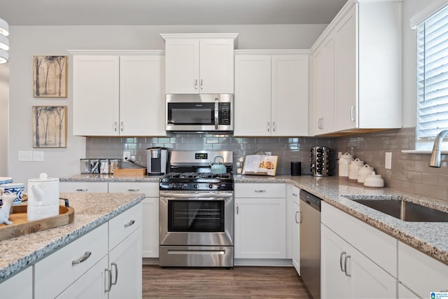 kitchen featuring backsplash, stainless steel appliances, and white cabinetry