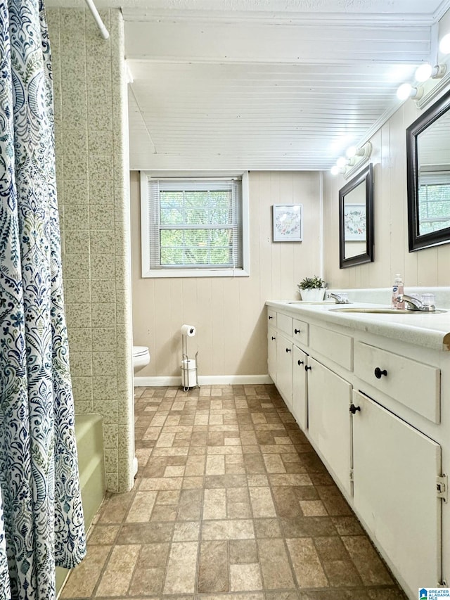 full bathroom with toilet, wood walls, vanity, tile patterned floors, and shower / bathtub combination with curtain