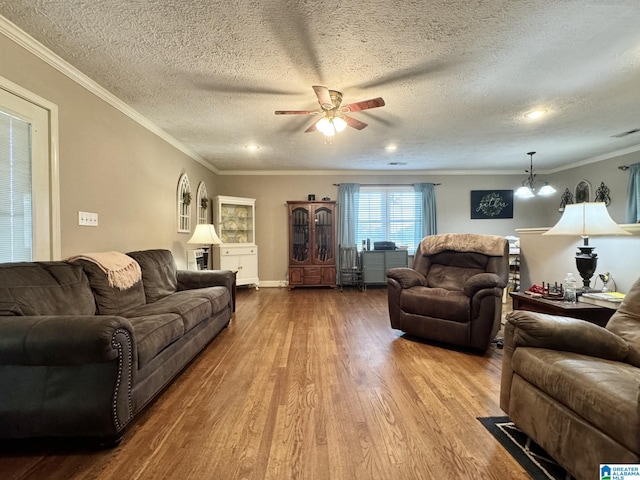 living room with a textured ceiling, ceiling fan, crown molding, and wood-type flooring