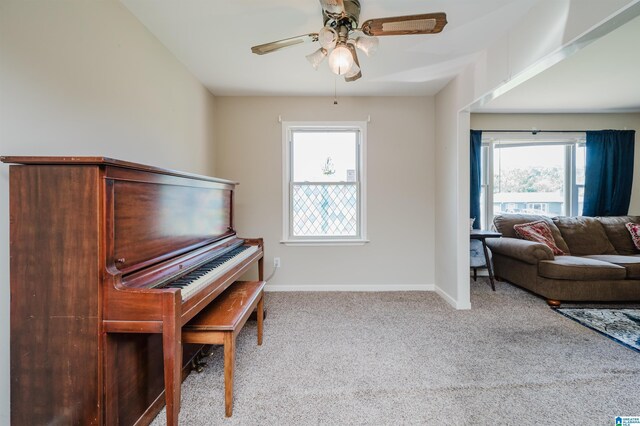 interior space with ceiling fan and light colored carpet