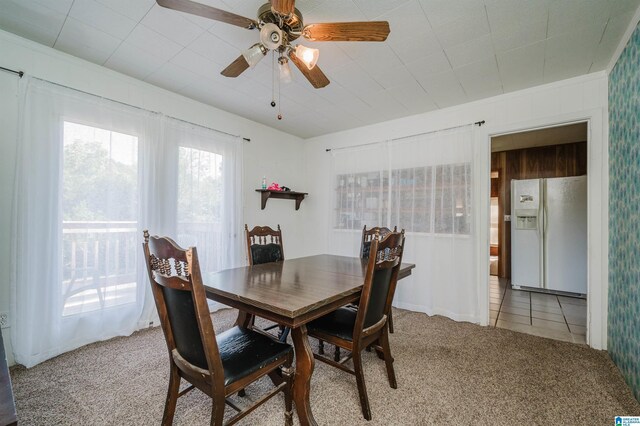 carpeted dining area with a wealth of natural light, ceiling fan, and crown molding