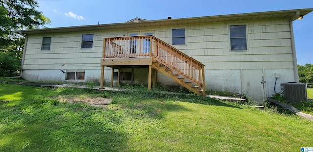 rear view of house with a yard, a deck, and central AC