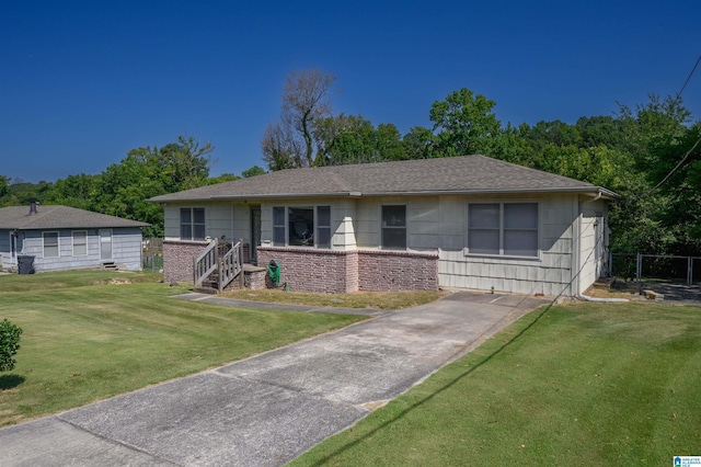 view of front of home with a shingled roof, a front lawn, and brick siding