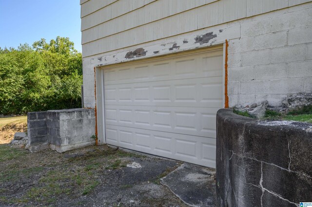 back of house with a garage, central AC, and a lawn