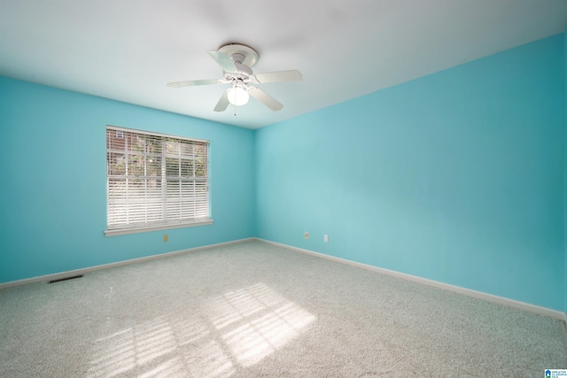 spare room with ceiling fan and carpet