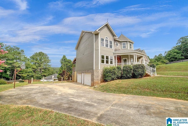 view of front of house with a porch, a front yard, concrete driveway, and an attached garage