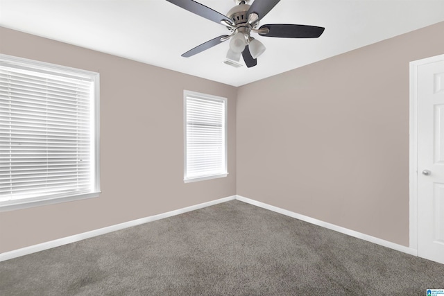 spare room with a ceiling fan, visible vents, baseboards, and carpet flooring