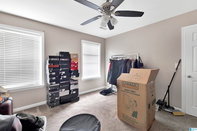 interior space featuring light colored carpet, visible vents, ceiling fan, and baseboards