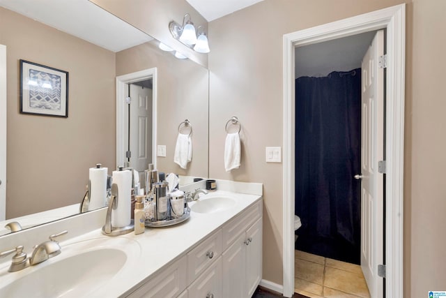 bathroom with double vanity, tile patterned flooring, toilet, and a sink