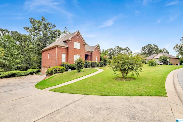 view of front of home with a garage, a front yard, brick siding, and driveway