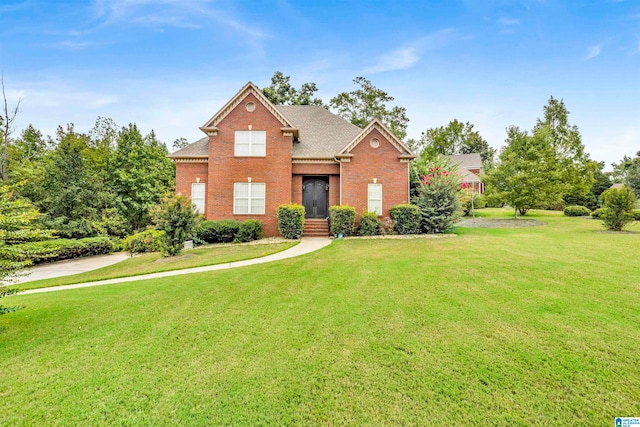 traditional-style home featuring roof with shingles, a front lawn, and brick siding