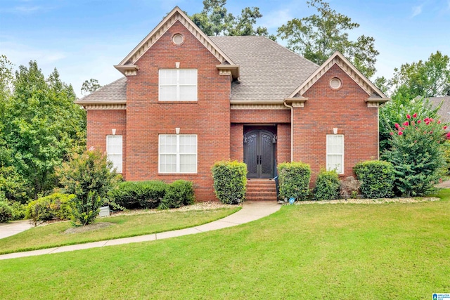 traditional-style home featuring brick siding, roof with shingles, and a front yard