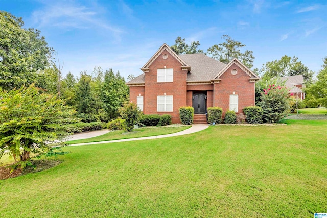 traditional-style home featuring brick siding, a shingled roof, and a front yard