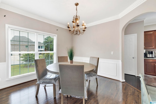 dining room with a wainscoted wall, dark wood-type flooring, arched walkways, and ornamental molding