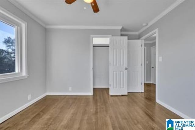 unfurnished bedroom with baseboards, wood finished floors, and crown molding