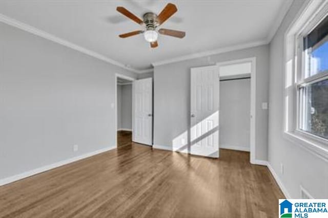 unfurnished bedroom with ornamental molding, dark wood finished floors, and baseboards