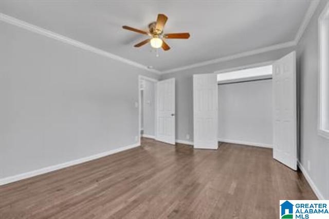 unfurnished bedroom featuring dark wood-style floors, ornamental molding, a closet, and baseboards