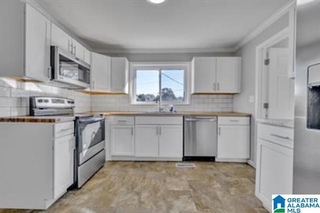 kitchen with white cabinets, stainless steel appliances, a sink, and light countertops