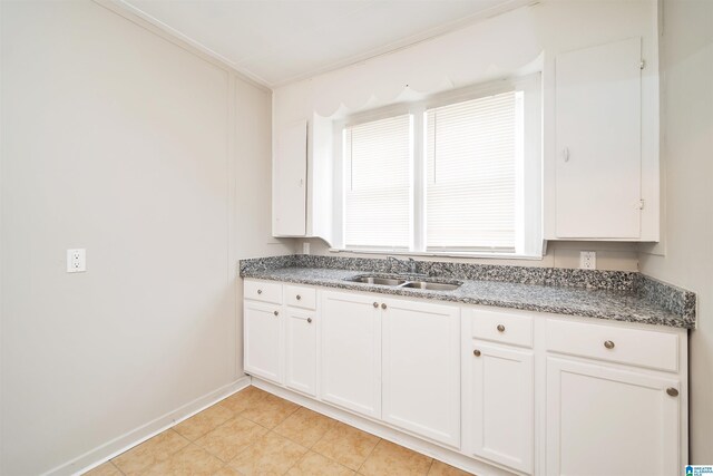 kitchen with sink, white cabinets, and light tile patterned floors