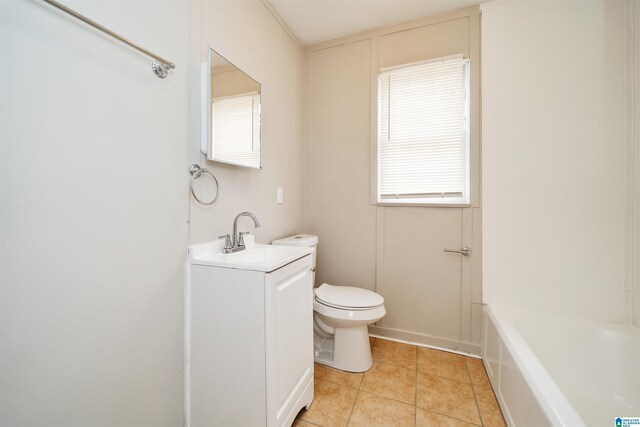 bathroom with a wealth of natural light, toilet, tile patterned flooring, and vanity