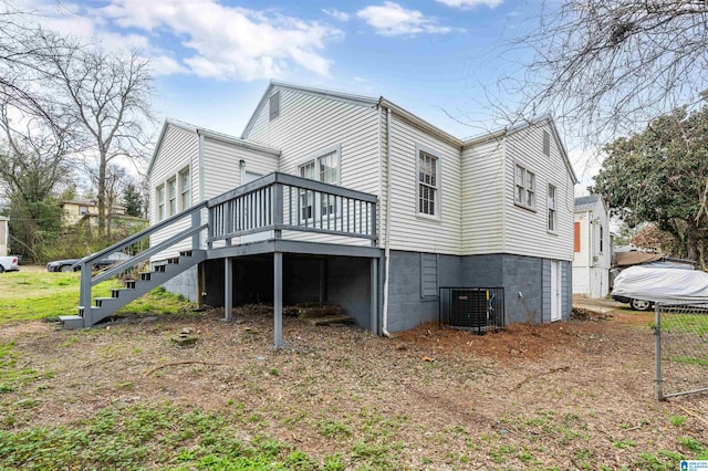 rear view of property featuring central AC unit and a wooden deck