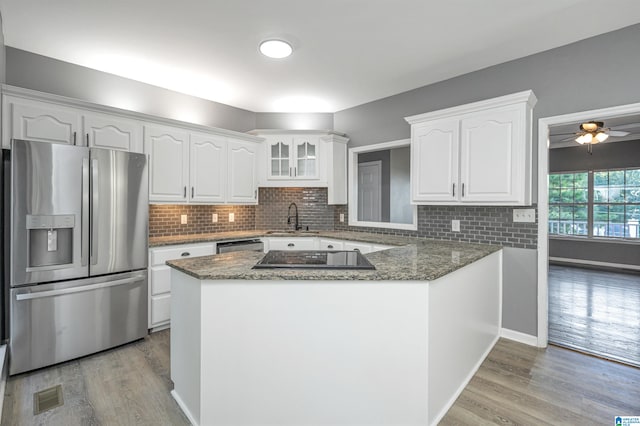 kitchen featuring appliances with stainless steel finishes, light hardwood / wood-style floors, and kitchen peninsula