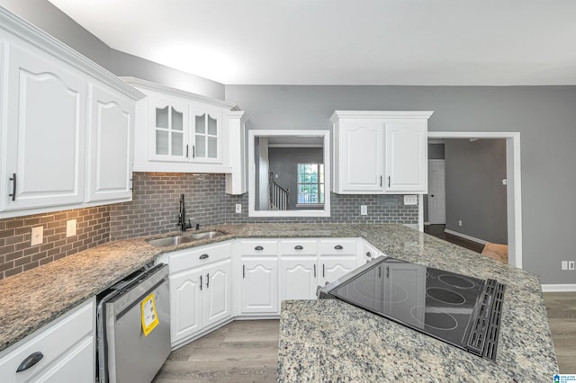 kitchen featuring white cabinets, light hardwood / wood-style flooring, stainless steel dishwasher, and light stone countertops