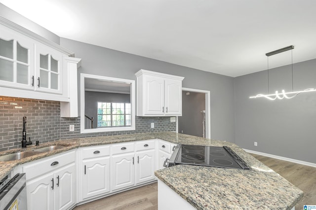 kitchen featuring sink, light hardwood / wood-style floors, stove, and tasteful backsplash