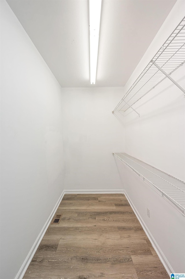 spacious closet featuring wood finished floors and visible vents