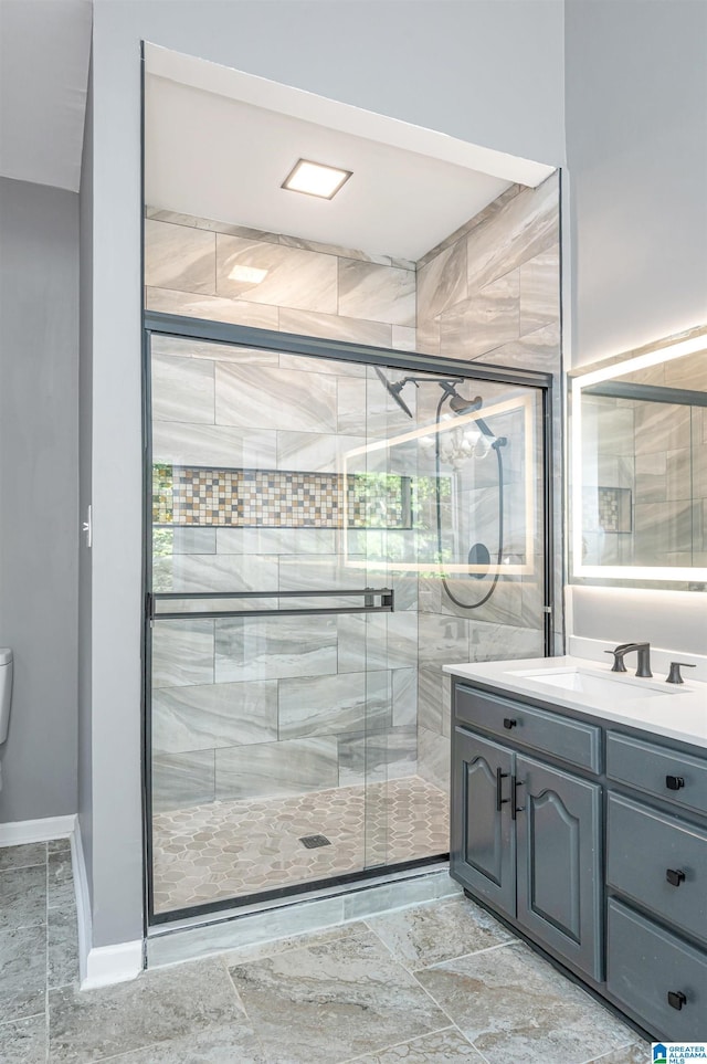 full bathroom featuring toilet, a shower stall, baseboards, and vanity