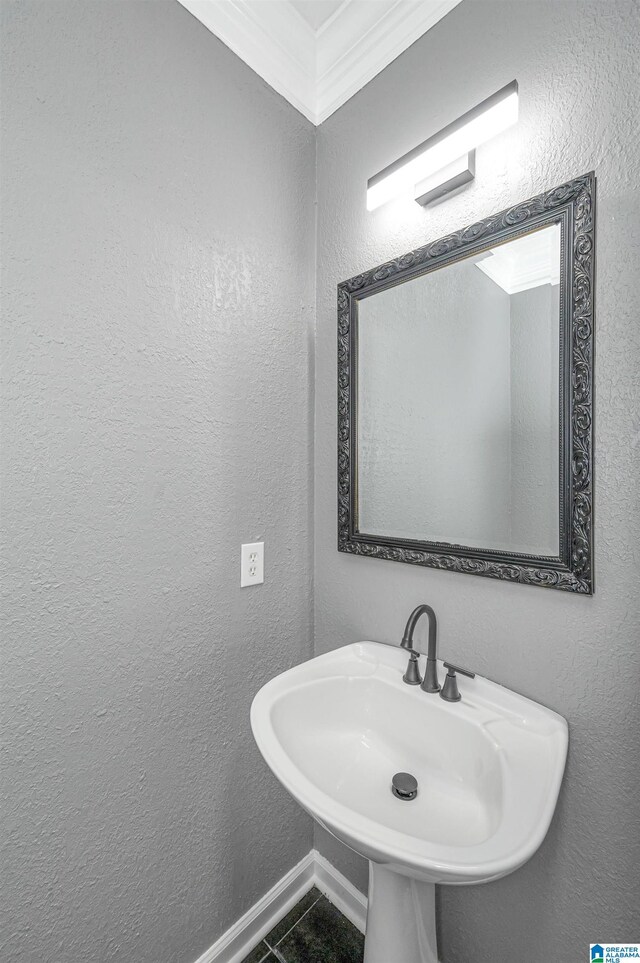 bathroom featuring a sink and a textured wall