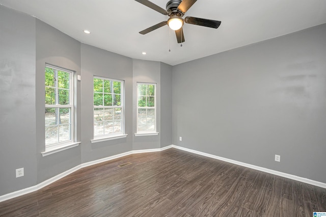 empty room with dark wood-type flooring, recessed lighting, visible vents, and baseboards