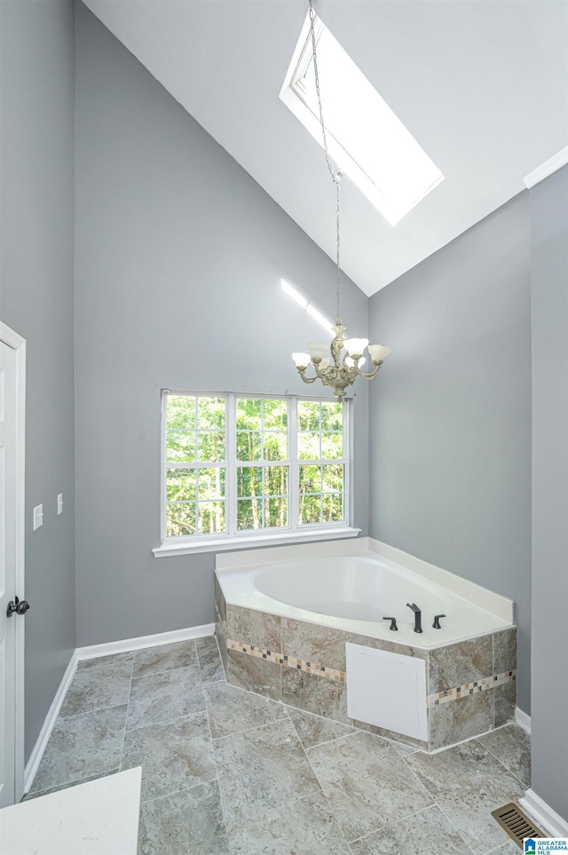 full bathroom with high vaulted ceiling, a skylight, a garden tub, and baseboards