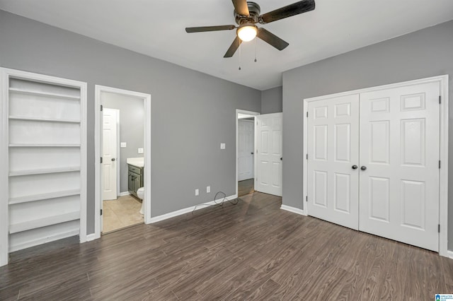 unfurnished bedroom featuring a closet, dark wood finished floors, a ceiling fan, and baseboards