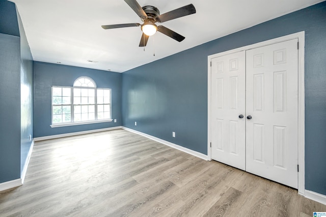 unfurnished bedroom featuring ceiling fan, a closet, and light hardwood / wood-style floors