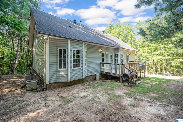 rear view of property featuring a wooden deck and central AC