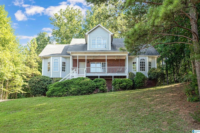 view of front of house featuring covered porch, a front lawn, a ceiling fan, and brick siding