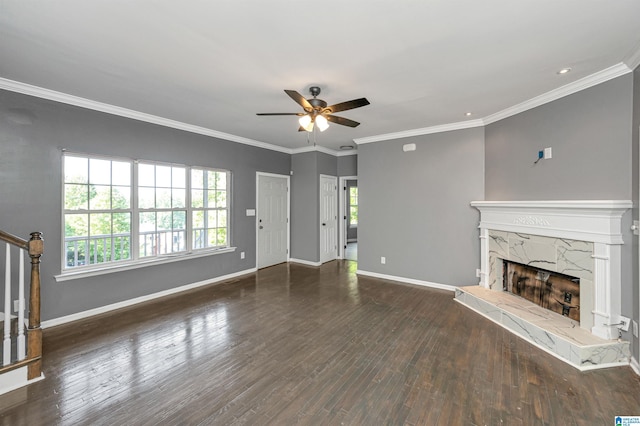 unfurnished living room with stairway, a premium fireplace, ornamental molding, wood finished floors, and baseboards