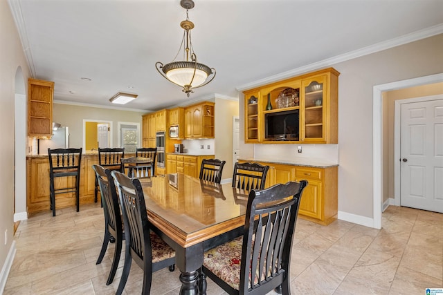 dining room with baseboards and crown molding