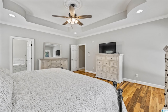 bedroom with baseboards, a tray ceiling, crown molding, light wood-type flooring, and recessed lighting