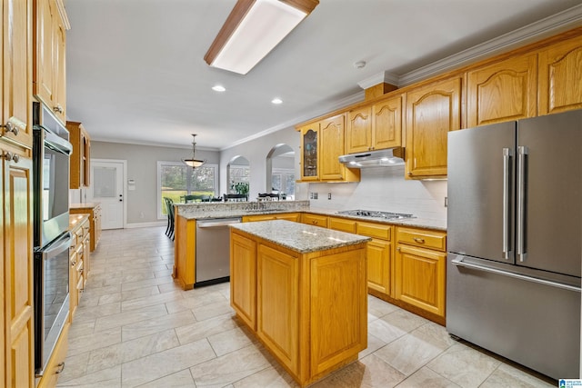 kitchen with arched walkways, appliances with stainless steel finishes, a peninsula, light stone countertops, and under cabinet range hood