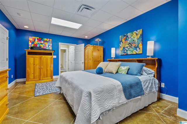 tiled bedroom with a paneled ceiling, visible vents, and baseboards