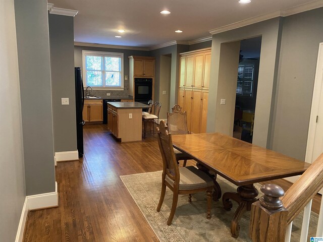 dining room featuring ornamental molding, dark wood-type flooring, recessed lighting, and baseboards