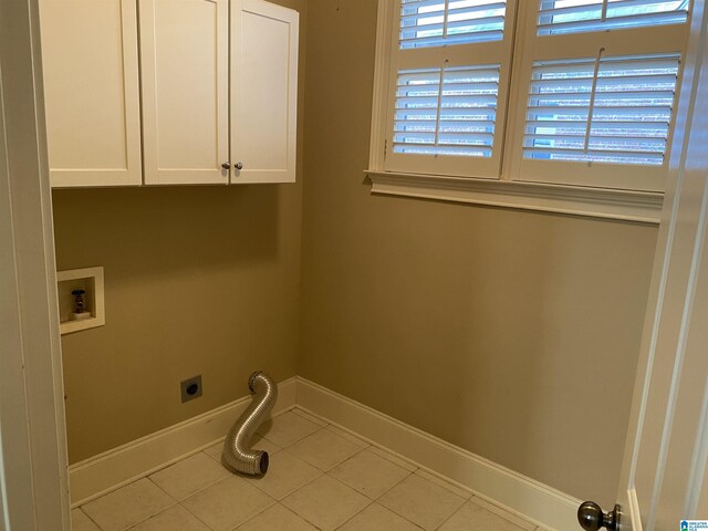 washroom with cabinet space, baseboards, tile patterned floors, hookup for a washing machine, and electric dryer hookup