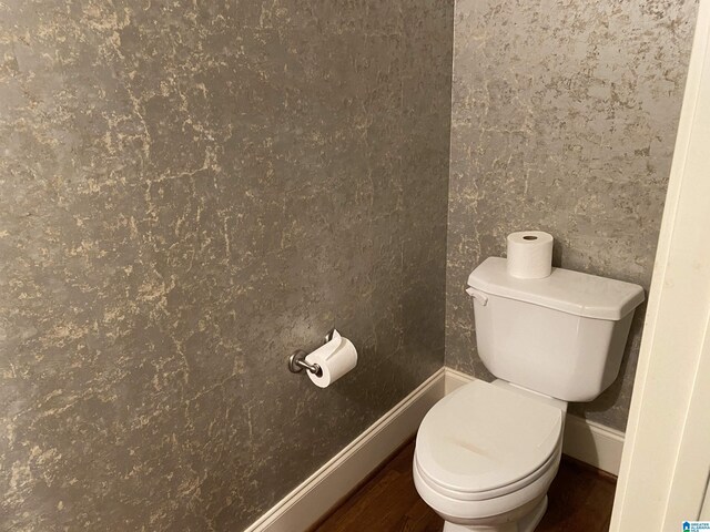 bathroom featuring toilet, baseboards, and wood finished floors