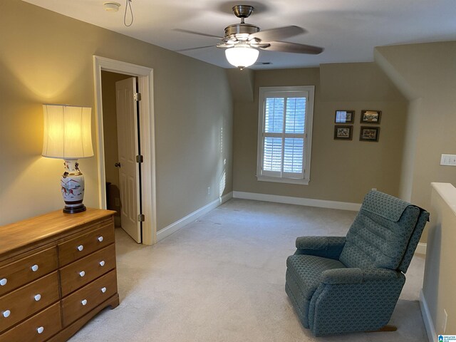 sitting room featuring a ceiling fan, light colored carpet, and baseboards