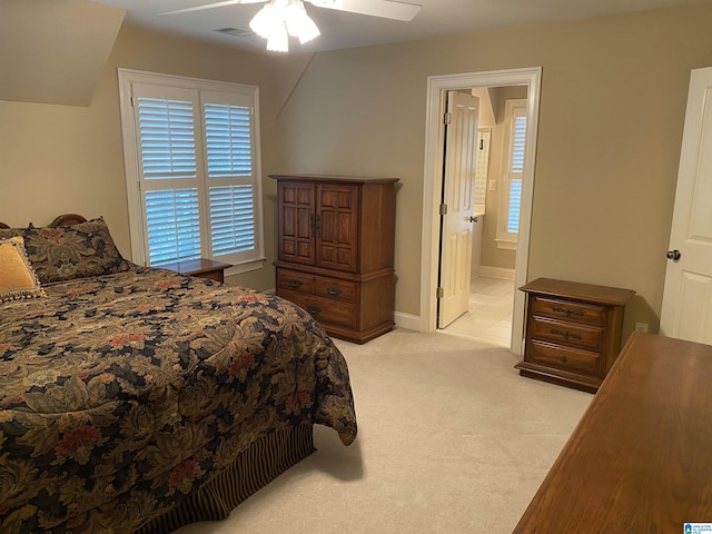 bedroom featuring visible vents, ensuite bathroom, light carpet, ceiling fan, and baseboards